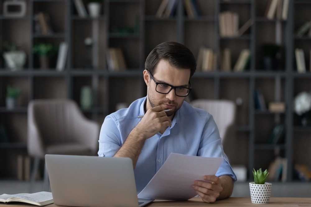 man with glasses working on taxes
