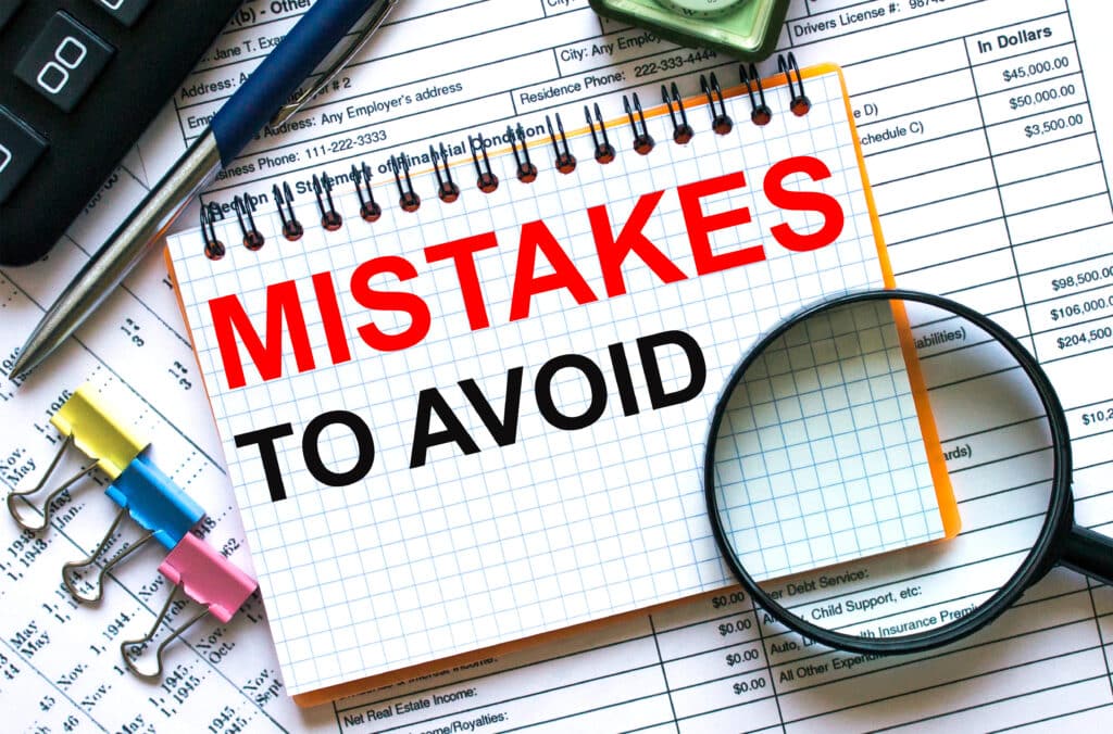 Text Mistakes To Avoid on notepad with calculator, clips, pen on FBAR financial report