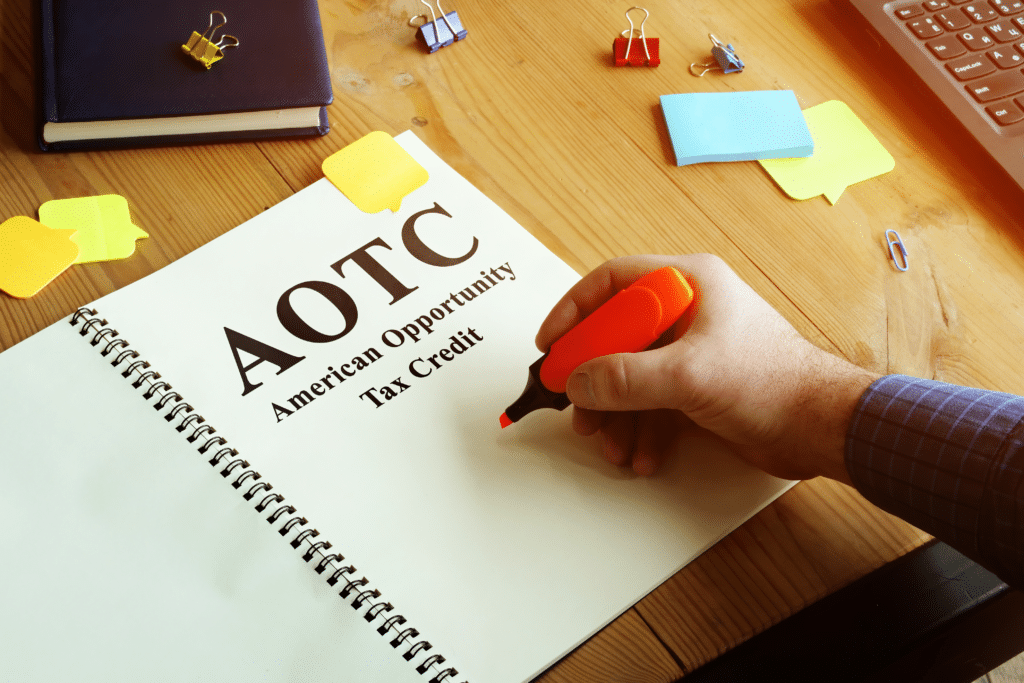 Person holding a highlighter and a book with the text ''AOTC American Opportunity Tax Credit''