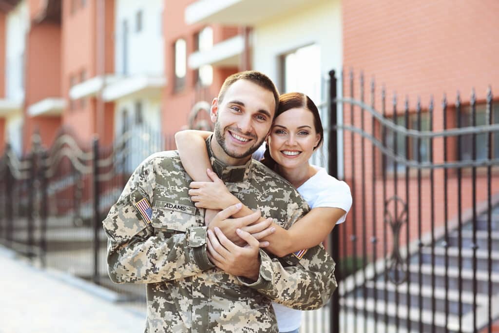 Happy US army soldier with his military spouse on street