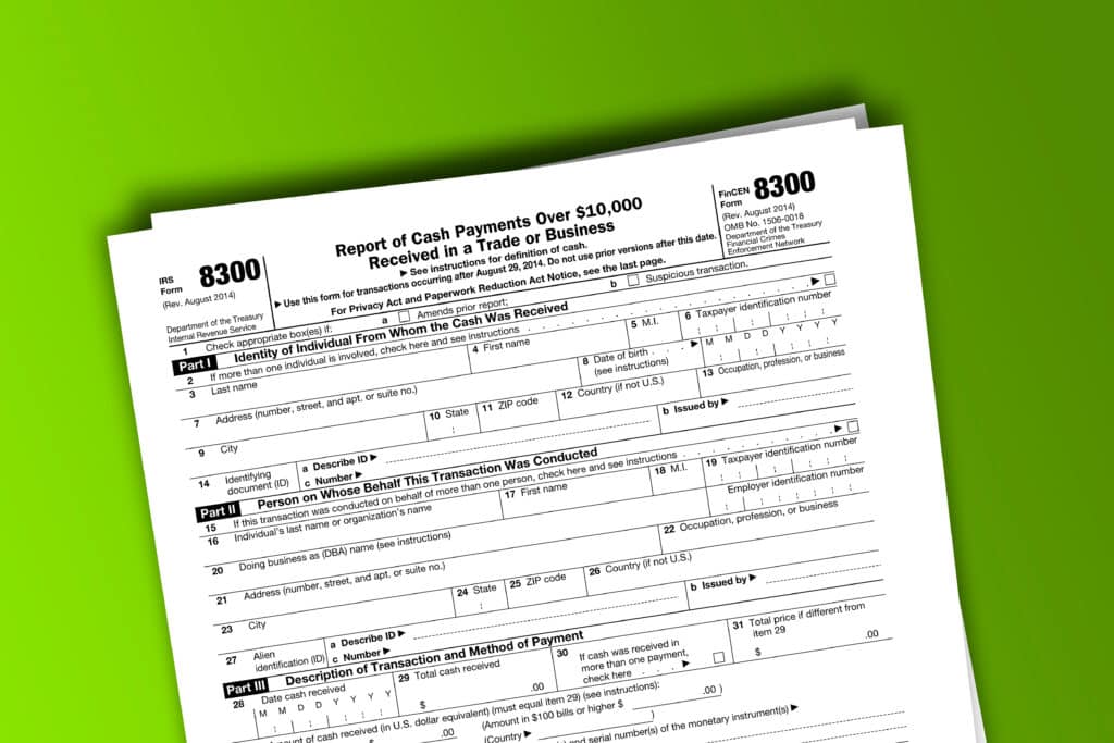 Form 8300 papers. Report of Cash Payments Over $10,000 Received In a Trade or Business. Form 8300 documentation published IRS USA 08.29.2014. American tax document on colored